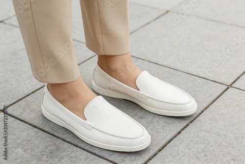 Person wearing white loafers on tiled ground