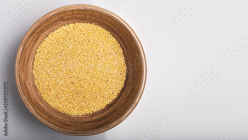 Canvastavla A clay bowl with millet on a white background