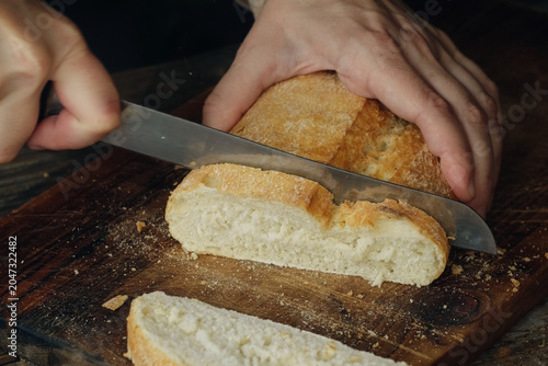 Cutting freshly baked crusty artisan loaf