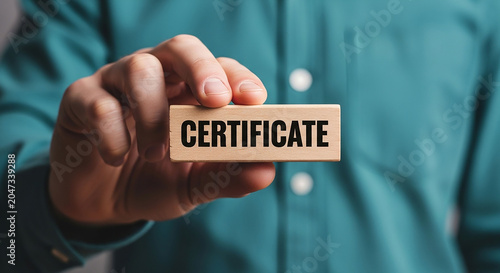 Certificate of Achievement: A close-up shot features a person holding a wooden block with the word CERTIFICATE engraved on it, symbolizing recognition and accomplishment.
