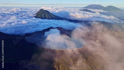 Aerial view of fog at Kawah Ijen volcano with turquoise sulfur water lake at sunrise.Amazing nature landscape view at East Java,Indonesia.Beautiful light Natural landscape background