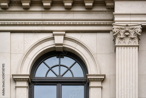 Renaissance-inspired symmetrical stone facade detail with arched window and pilaster