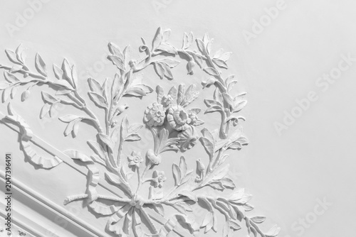 Foto Ornate white plaster floral relief adorns a classical ceiling with detailed deco