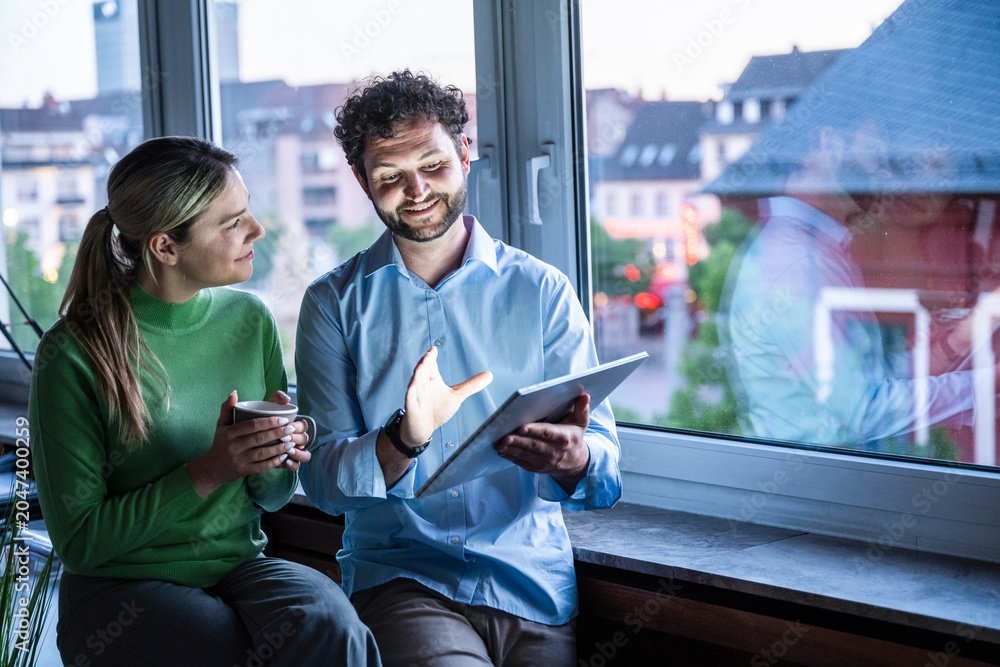 © BusinessClass by W61 - Colleagues discuss business strategy on a tablet in the office