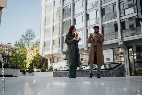 фотографія A young stands in an urban plaza eating street food together