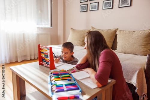 Mother helping son with homework and studying for school