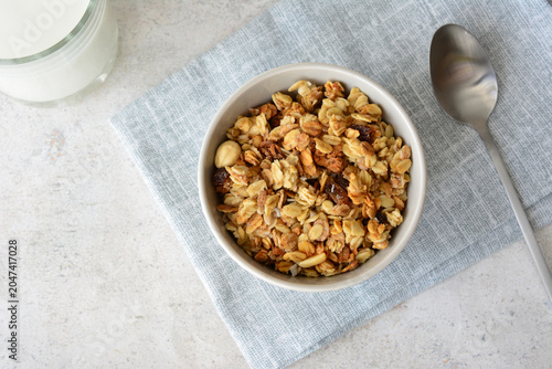 a flat lay of Granola in a bowl with milk and spoon