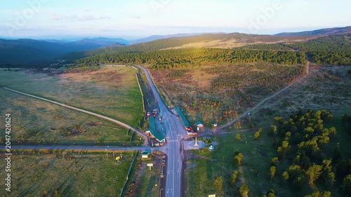 Aerial view of winding forest road at golden hour intersection