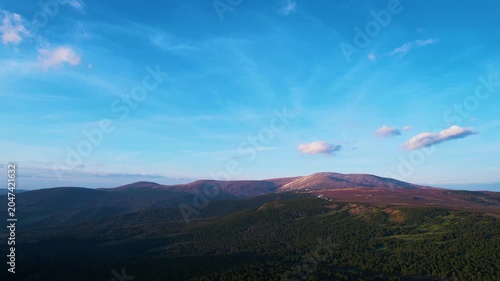 Mountain landscape with blue sky and forested foreground