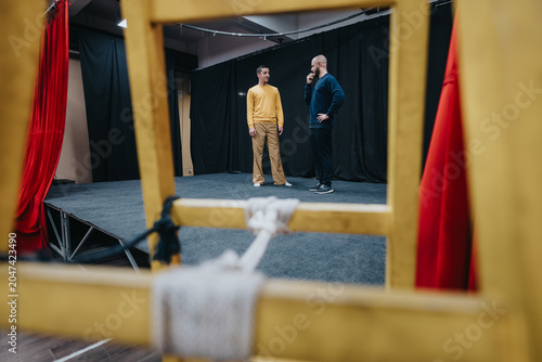 Foto Two young actors stand and talk on a small theater stage during rehearsal
