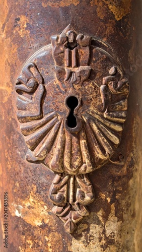 Rusty Antique Door Lock with Ornate Keyhole on Weathered Metal Surface