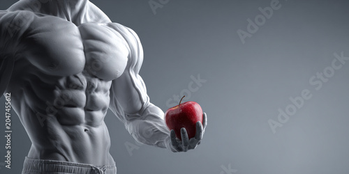 Muscular man holding red apple, showcasing defined muscles and strength, symbolizing health and fitness