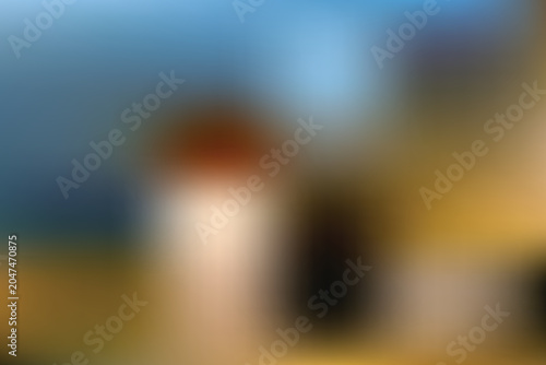 A serene landscape with a blurry lighthouse standing tall on a sunny day.