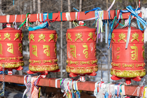 Fotografie Close-up of red Buddhist prayer wheels decorated with gold symbols and colorful