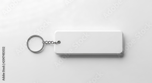 Minimalist top view of a blank rectangular white keychain with a metal ring and chain placed on a clean white background, ideal for mockups or branding presentations.