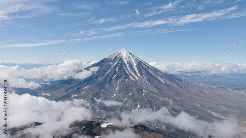 Foto Aerial view of Koryaksky volcano peak above low clouds on a clear day near Petro