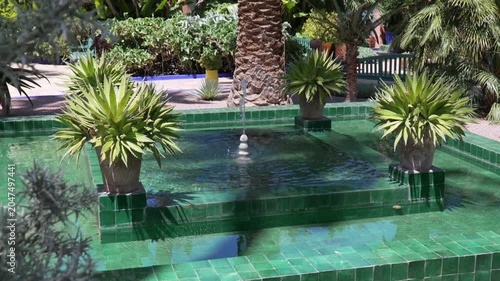 Tranquil Jardin Majorelle fountain with green tiles and lush plants