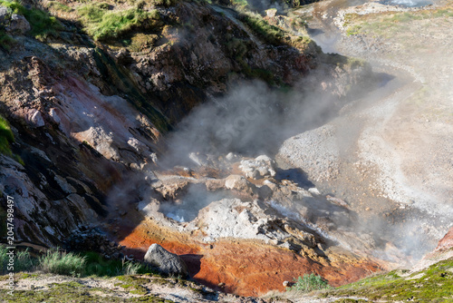 Tableau sur toile Geothermal steam rises from hot springs and fumaroles among colorful mineral dep