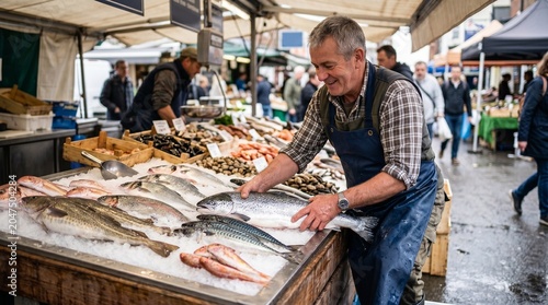 Smiling fishmonger arranging fresh salmon and cod on ice at an outdoor market stall with customers in the background
