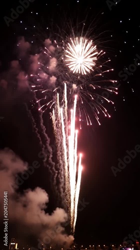 Large golden firework burst with smoke trails at night.