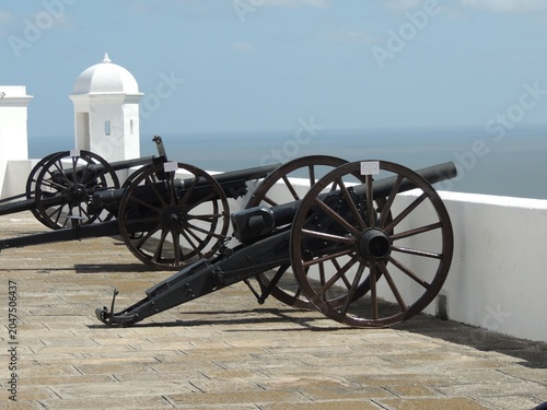 Fotografie Historic black iron cannons on the ramparts of a colonial fortress overlooking the Rio de la Plata in Colonia del Sacramento, Uruguay