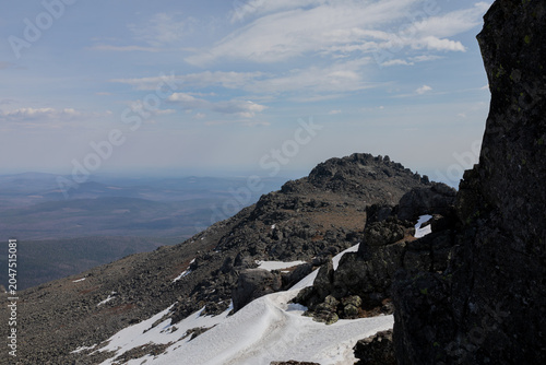 Bild auf Leinwand Wide view from Konzhakovsky Stone showing rocky tundra ridge, lingering snowfiel