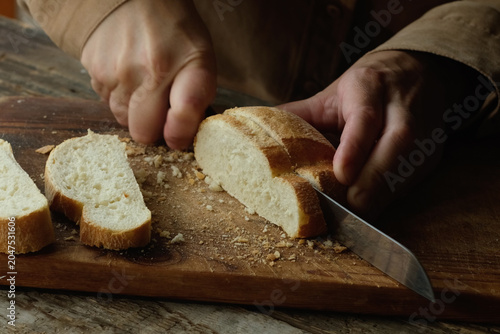Slicing freshly baked loaf of artisan ciabatta bread with a knife