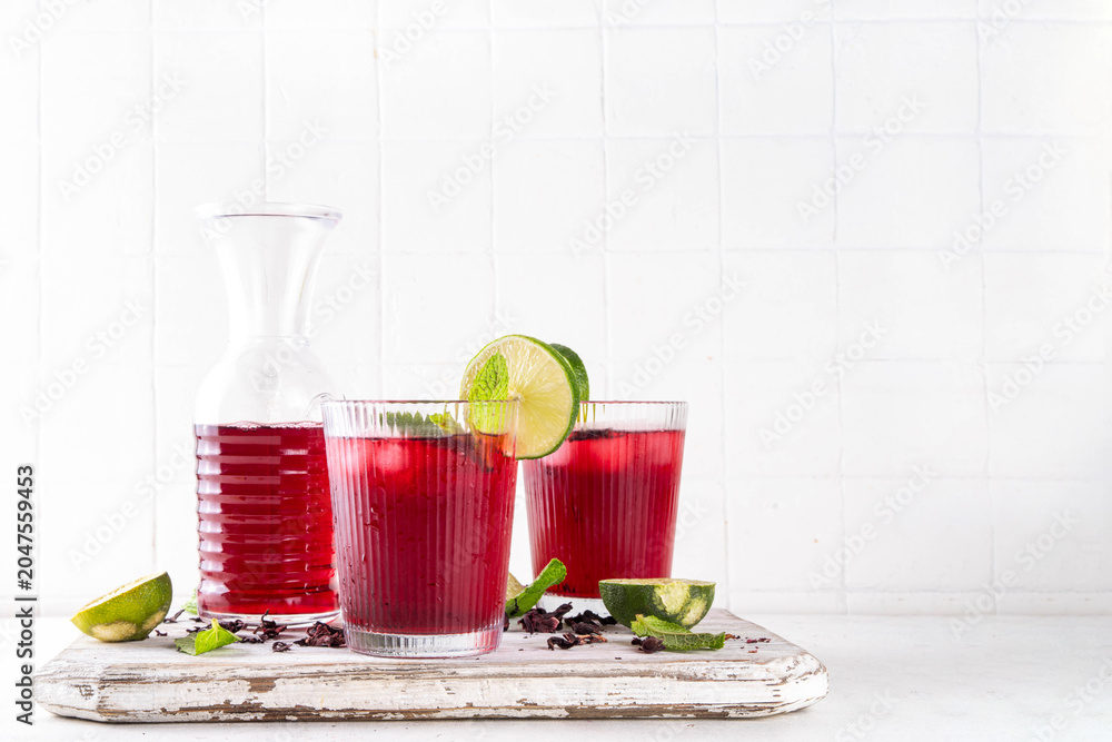 Fototapeta premium Iced Hibiscus Tea Recipe, traditional summer Agua de Jamaica. Summer cold refreshing drink - tea or juice with ice and mint, copy space