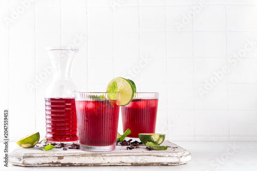 Iced Hibiscus Tea Recipe, traditional summer Agua de Jamaica. Summer cold refreshing drink - tea or juice with ice and mint, copy space