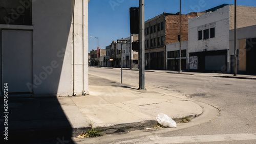 empty summer city street at noon with abandoned plastic bag