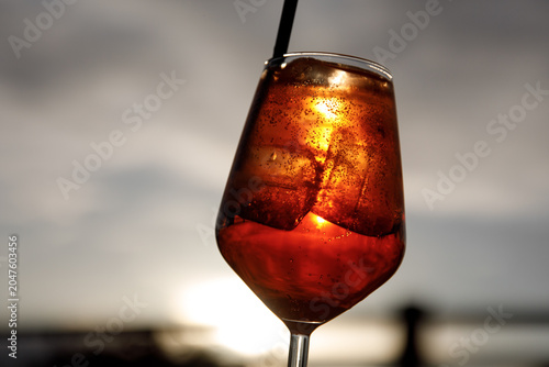 фотографія Close-up of a refreshing orange cocktail glass at sunset