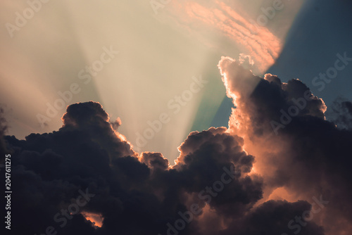 the sun's rays break through the clouds at sunset