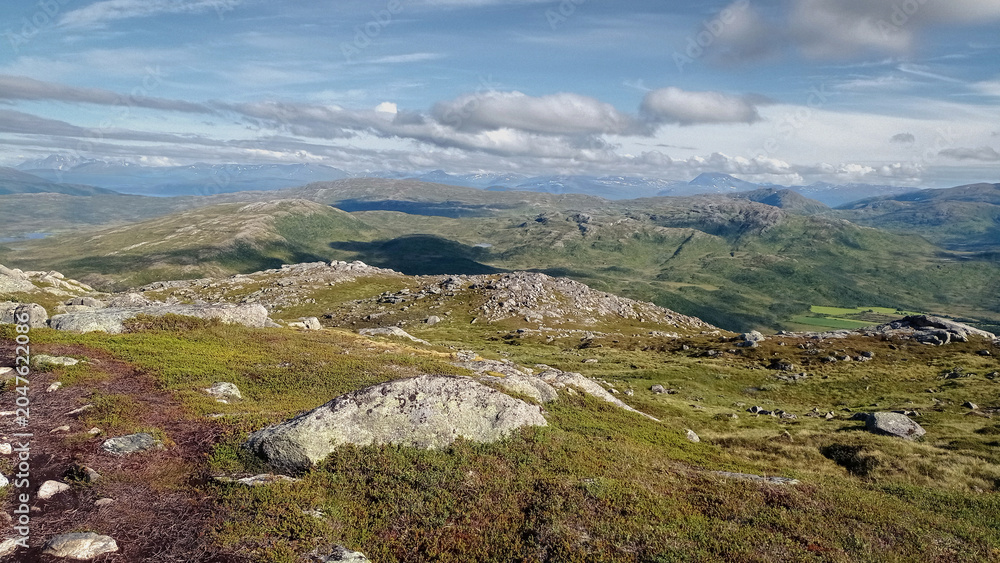 Fototapeta premium Panoramic view of Arctic tundra landscape and fjords from Nattmalsfjellet mountain in Kvaloya Island, Tromso, Northern Norway. Hiking trail view over majestic hills near Tromso region.