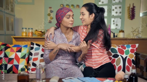 Female cancer patient after her chemotherapy spending some time with family. Young daughter hugging her unhealthy mother and giving love and support to her - care and support
