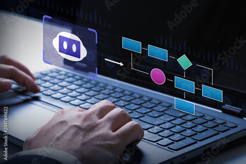 Automated Workflow on Laptop: A close-up shot of hands typing on a laptop keyboard, with a digital flowchart and chatbot interface displayed on the screen, symbolizing automation and technology.