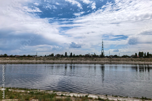 Canal Waterfront Landscape Under Expansive Cloudy Sky