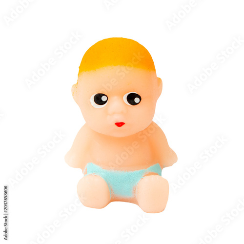 Cut out Small rubber baby doll isolated on a black background. Cute tiny plastic baby toy sitting on solid black surface, close-up view. PNG.