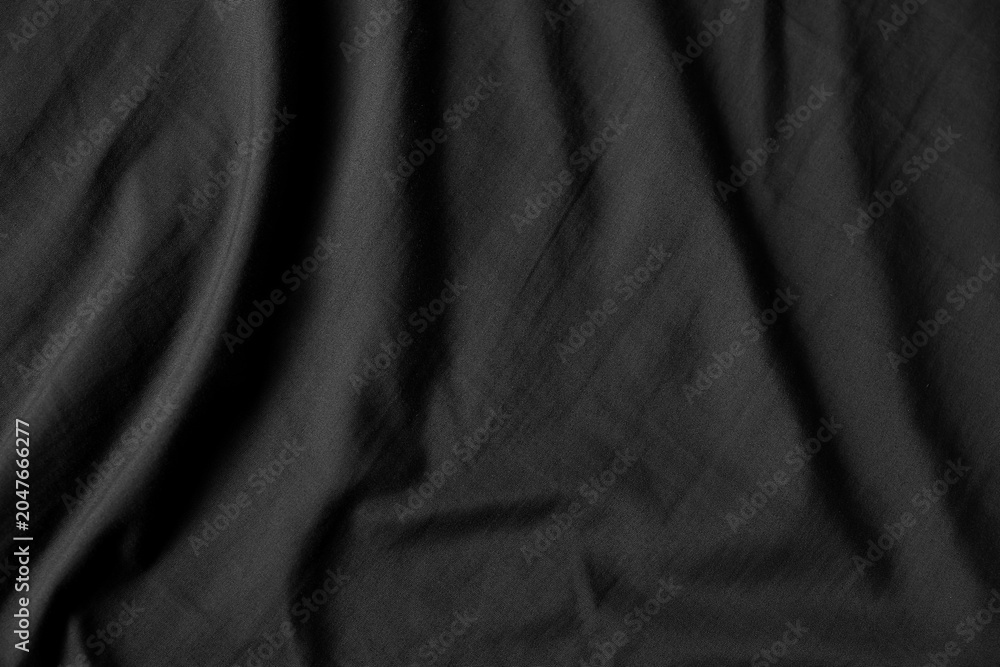 Fototapeta premium Close up black wrinkled fabric texture rippled surface, Soft focus.