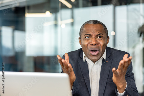 Фотография Mature adult businessman expressing intense shock, surprise, and dissatisfaction