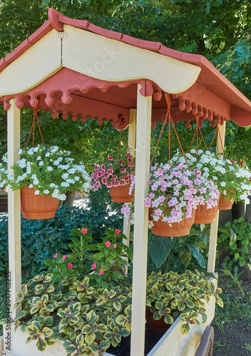 Decorative cart. Flowers in pots suspended on a rope.	