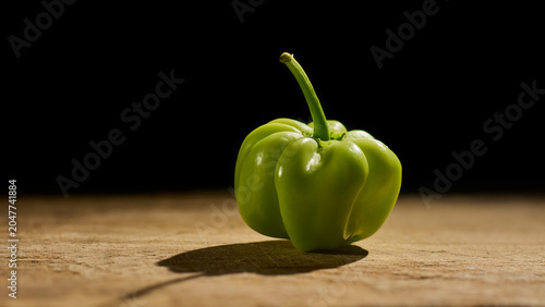 Fotografía green habanero chili on rustic wood isolated black background, fresh unripe spic