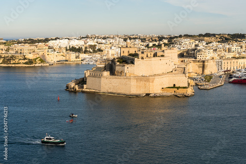 View of the historic Fort Saint Angelo bastions overlooking the Grand Harbour with boats on the water in Valletta, Port Region, Malta.