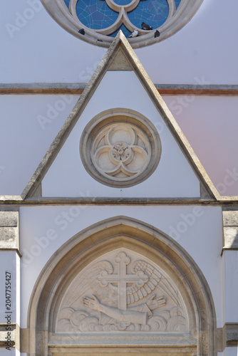 Fotografija Neo-gothic architectural details showing an arched portal tympanum with franciscan cross and geometric stone relief designed by Hermann Bolle on Saint Francis of Assisi Church from the 19th century