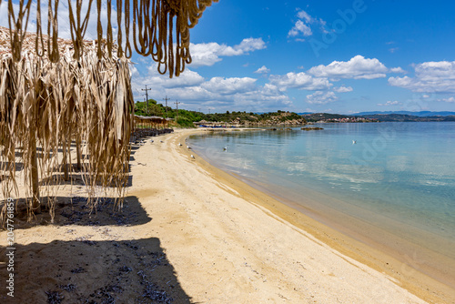 Beach with a bunch of straw umbrellas on it, Ammoulliani, Greece