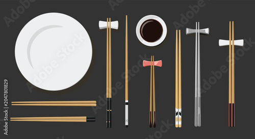 Set of various wooden and metal chopsticks with different rests, a soy sauce bowl, and a white plate on a dark gray background table.