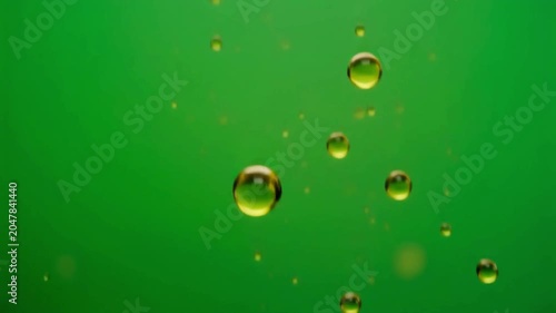 Oil droplets floating in air isolated on a green screen