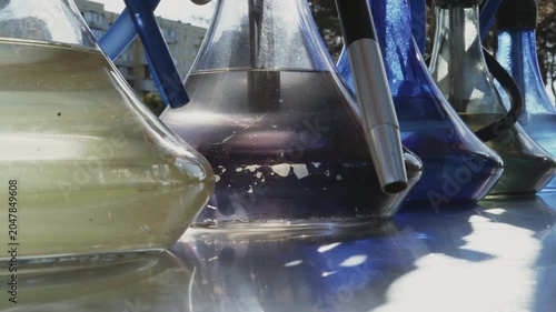 Close-up, hookahs filled with water stand on a counter in the park, glowing with the setting sun