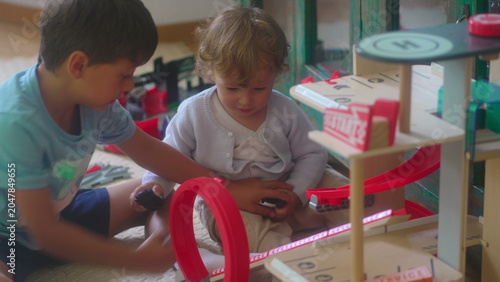 Foto Toddler grabbing toy car from older sibling during indoor playtime before siblin