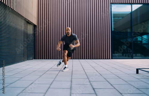 Handsome sportive man in athletic wear doing workout exercise, athlete enjoying an outdoor run session in city, fitness motivation and urban wellness