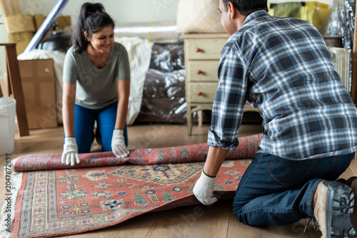 Photography Couple rolling Persian rug together